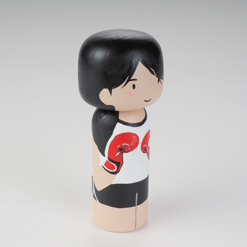 Kicking boxing Kokeshi doll. Introducing our new family portrait Kokeshi dolls!  Give something unique and personalized.  Customize your family, friends, or colleagues on Kokeshi dolls!  They are hand-painted with love that show the uniqueness of each individual such as specific sports or hobby.  Here is a family member who loves kickboxing but we can customize any sports or hobby.