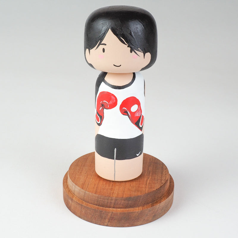 Kicking boxing Kokeshi doll. Introducing our new family portrait Kokeshi dolls!  Give something unique and personalized.  Customize your family, friends, or colleagues on Kokeshi dolls!  They are hand-painted with love that show the uniqueness of each individual such as specific sports or hobby.  Here is a family member who loves kickboxing but we can customize any sports or hobby.